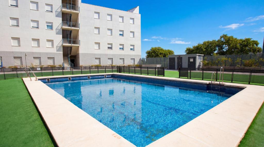 ein Schwimmbad vor einem Gebäude in der Unterkunft Apartamentos Vértice Sevilla Aljarafe in Bormujos