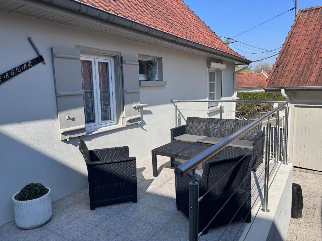 a patio with a table and chairs on a balcony at le relais des étangs B in Mareuil-Caubert