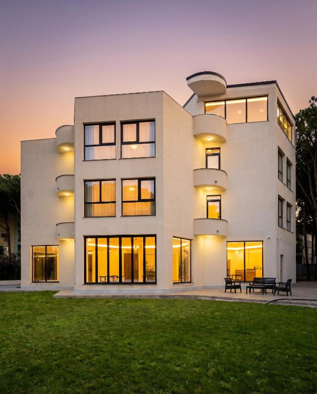 a large white building with a park in front of it at The Honeycomb Boutique Hotel in Golem