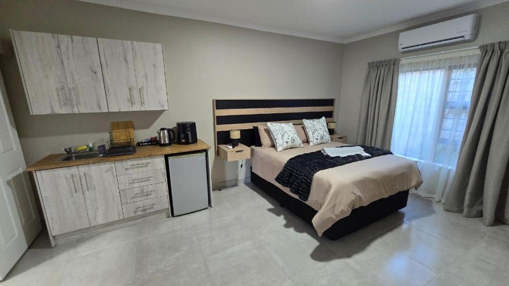 a bedroom with a large bed and a desk with a microwave at Waverley Rest in Bloemfontein