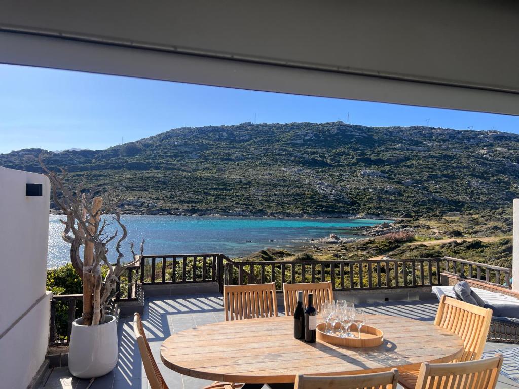 a dining table on a balcony with a view of the ocean at villa rêve in Calvi