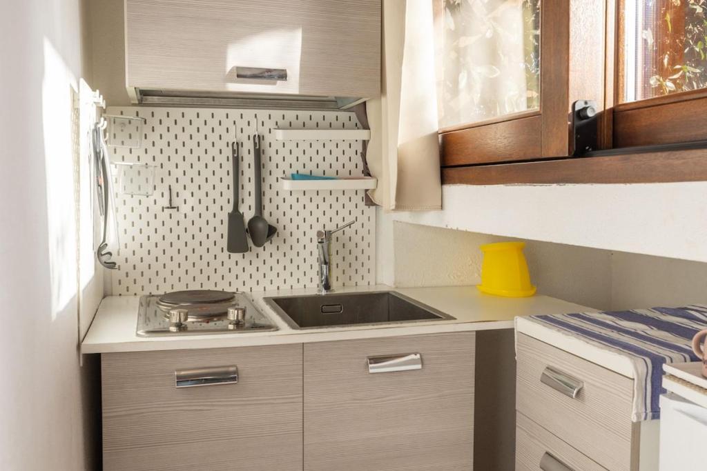 a small kitchen with a sink and a stove at Ventimiglia Garden Suite in Olbia