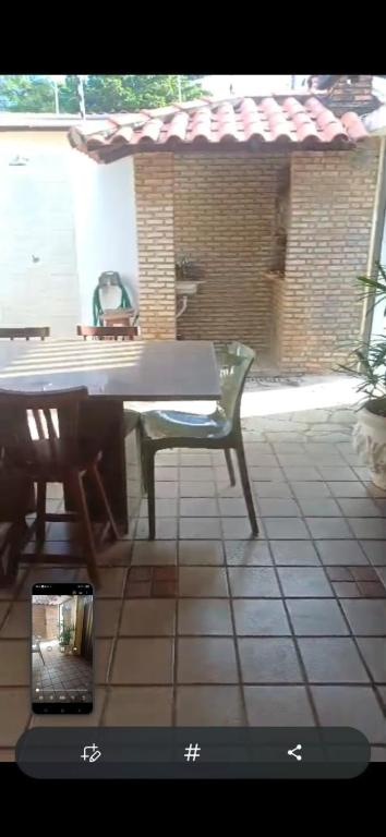 a table and a green chair on a tiled patio at Aconchego perto da praia in Aracaju