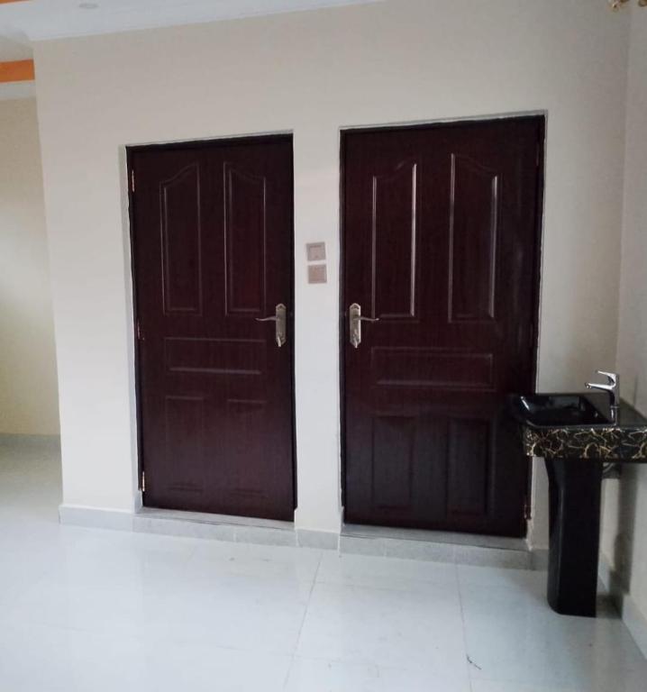 two brown doors in a room with a table at Haven Breeze Villas in Nakuru