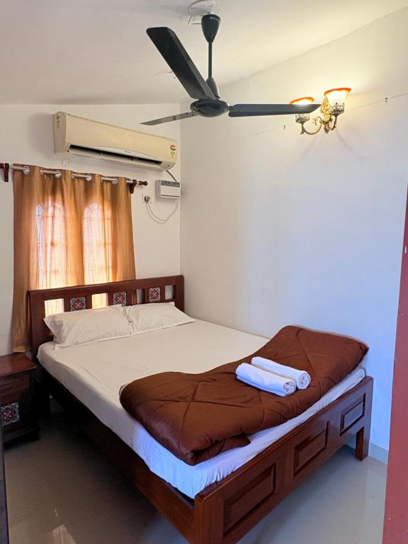 a bedroom with a bed with a ceiling fan at Rainbow721 in Pondicherry