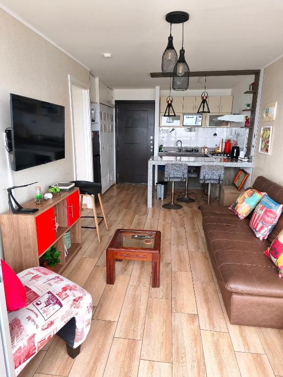 a living room with a couch and a table and a kitchen at EuVe Ocean View Flat in Lima in Lima