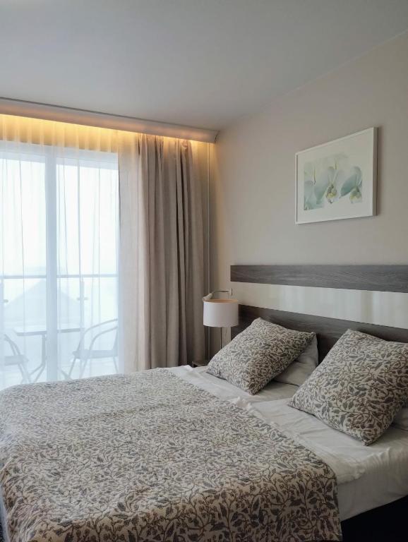 a bedroom with a bed and a large window at Apartament Bormio MarsMed in Biała Woda