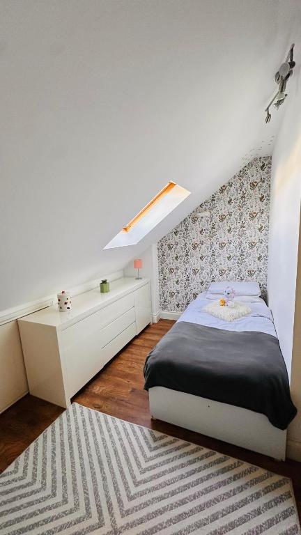 a bedroom with a bed and a desk and a rug at Broadway Apartment in London