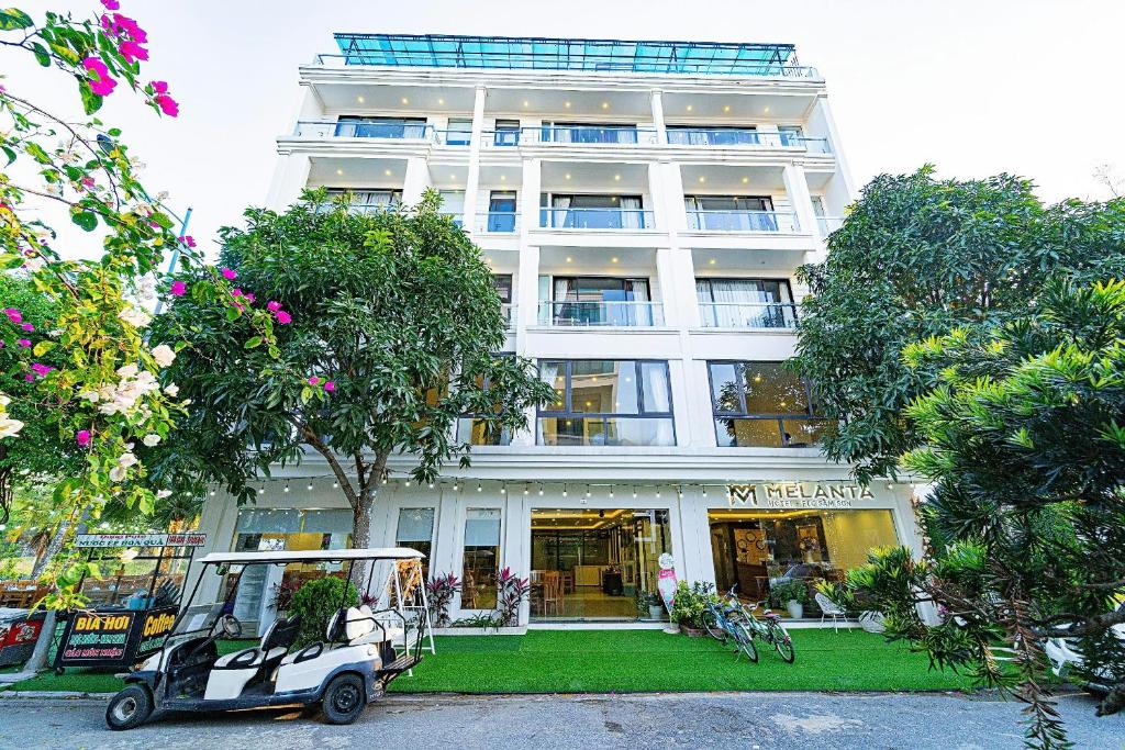 a golf cart parked in front of a building at Khách Sạn Melanta - FLC Sầm Sơn in Sầm Sơn