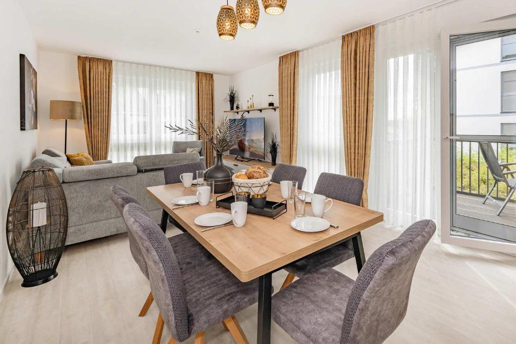 a living room with a dining room table and chairs at Hart Backbord in Loddin