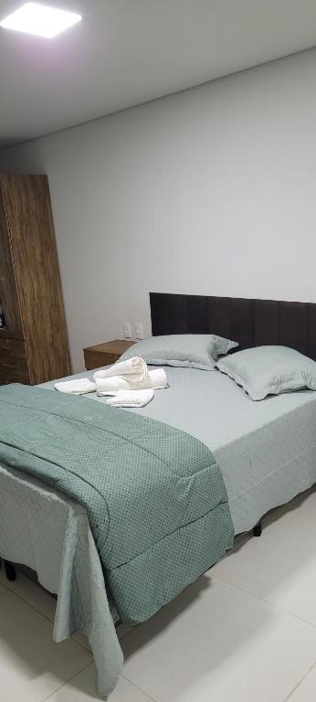 a bedroom with a bed with a green blanket at Serra & Sossego in Araras Petropolis