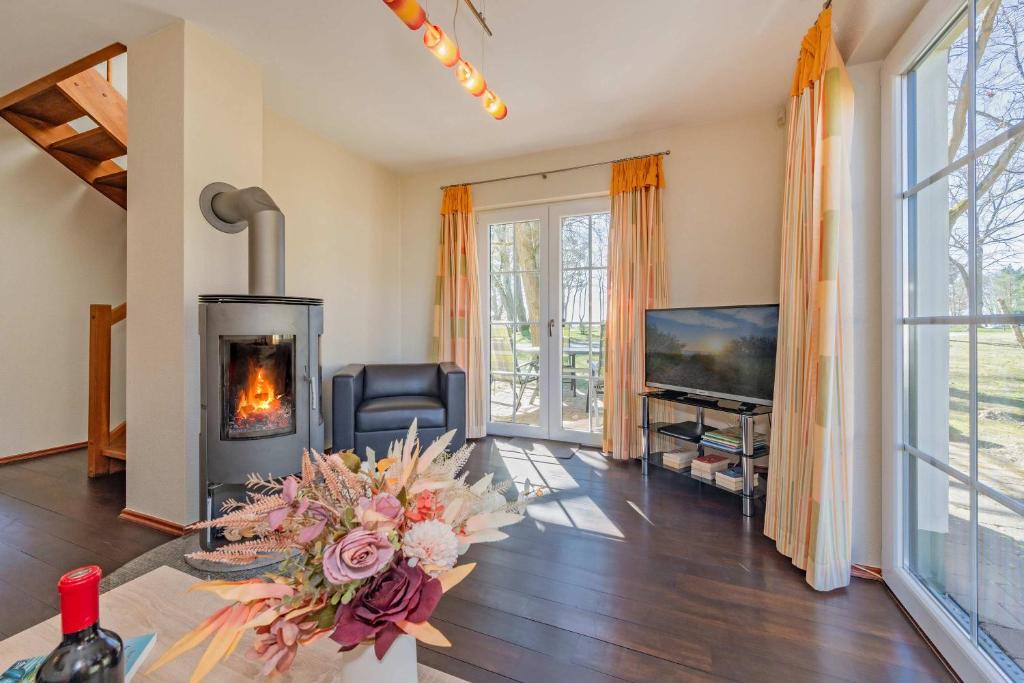 a living room with a fireplace and a tv at Ferienhaus "Ferien am Haff" in Zirchow