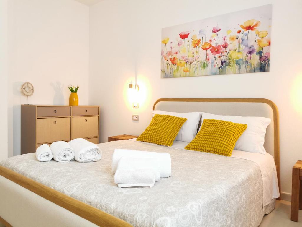 a bedroom with a bed with towels on it at Domus Soli in Teulada