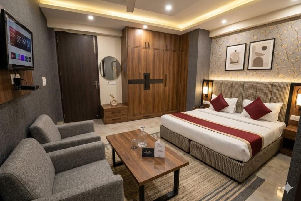 a hotel room with a bed and a living room at Hotel Yuvraj 5 Mints walking from Rajendra Nagar Metro Station in Ghaziabad