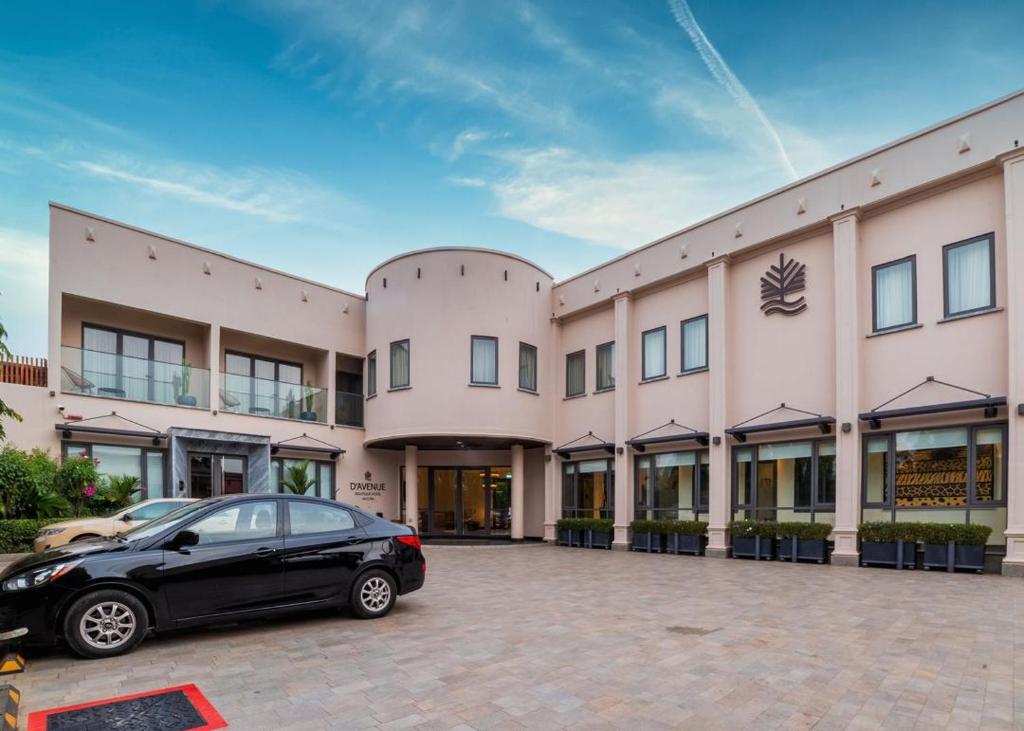 a black car parked in front of a building at D'avenue Boutique Hotel Accra in Accra