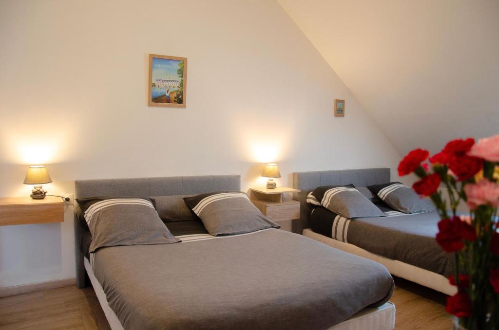 three beds in a room with red flowers and lamps at Le Relais de Poste in Orbigny