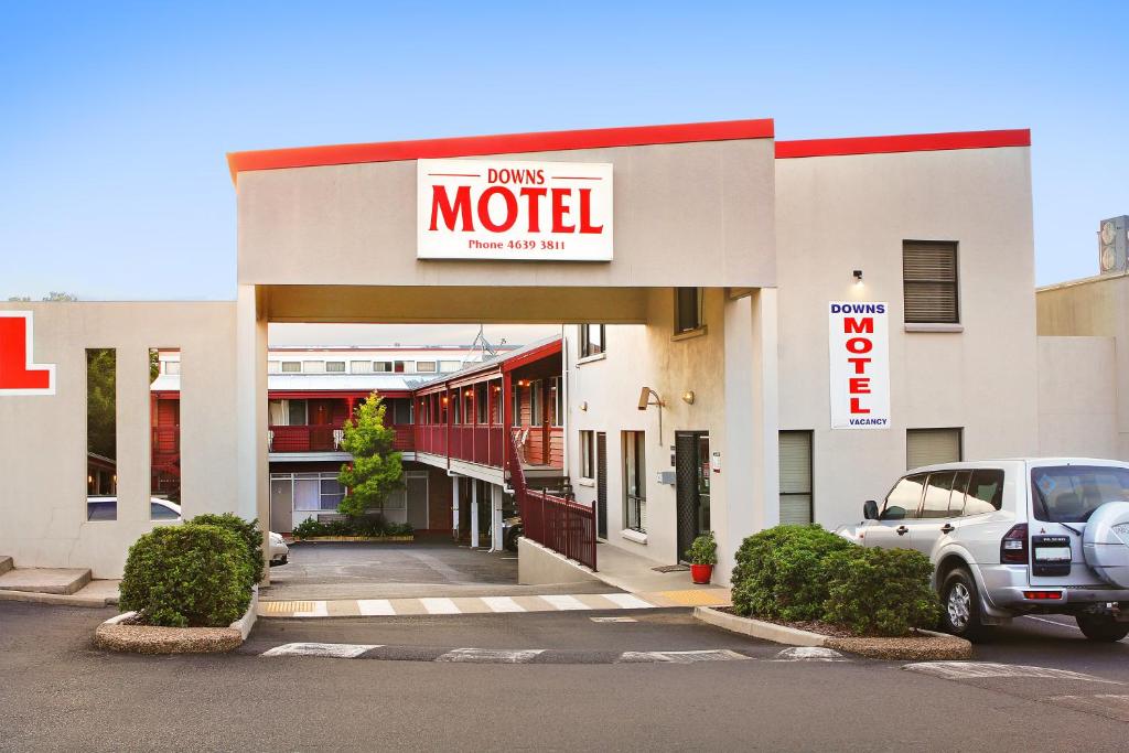 a motel with a car parked in a parking lot at Downs Motel in Toowoomba