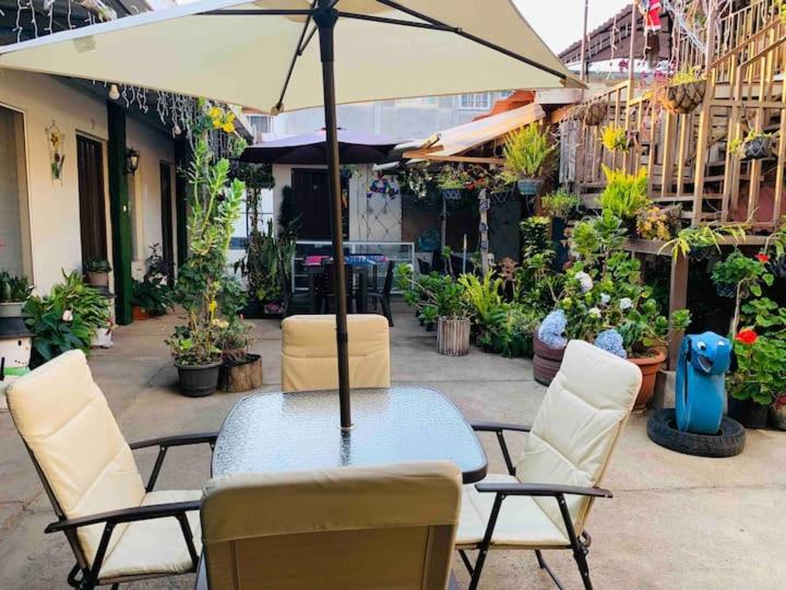 a table with chairs and an umbrella on a patio at Hostal Inmaculada in Concepción de Ataco