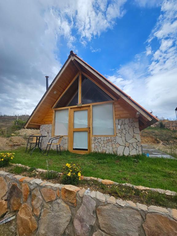 a house on a hill with a stone wall at Alpine Lake Lodge Hotel in Cajamarca