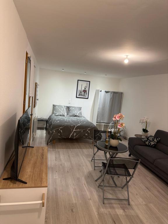 a living room with a bed and a table at Studio, atypique in Chaufour-lès-Bonnières