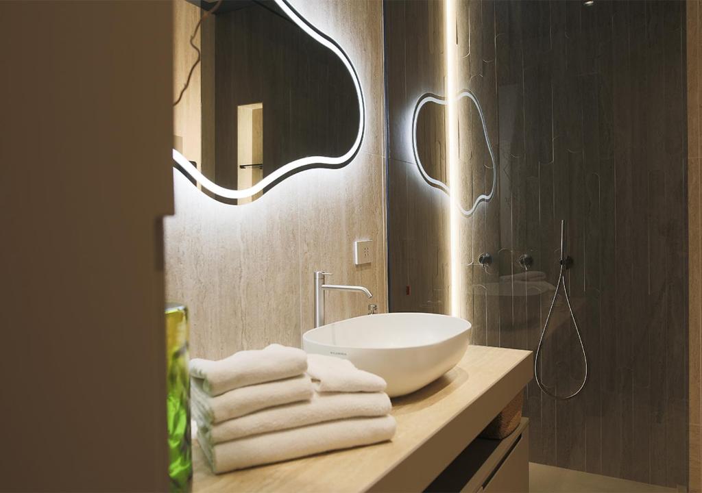 a bathroom with a sink and a mirror and towels at Lanza Luxury Home in Verona