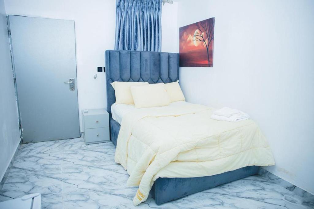 a bedroom with a bed with a blue headboard at Billionaire Apartment in Lekki