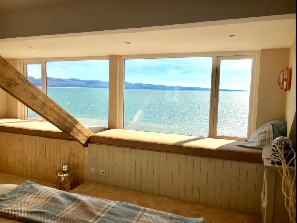 a bedroom with a large window overlooking the water at The View in Criccieth