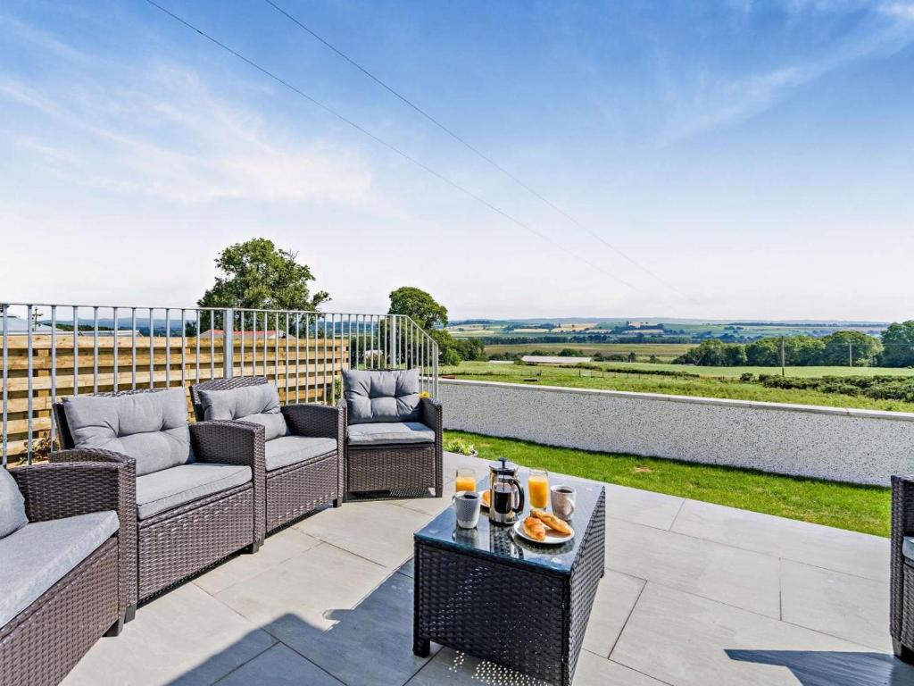 an outdoor patio with wicker chairs and a table at 3 Bed in Dumfries oc-96066 in Dumfries