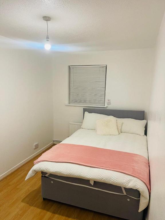 a small bedroom with a bed with a red blanket at 8 mins Drive from Heathrow - Double bedroom in shared accommodation - Cavalier Gardens in Hillingdon