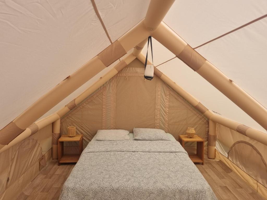 ein Zimmer mit einem Bett in einem Zelt in der Unterkunft La tente de Tom in Salazie