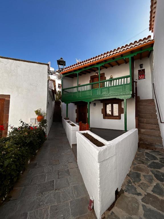 a white building with a green balcony on it at Balcón Néstor Álamo I in Tejeda