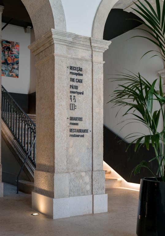 A stone column in the interior atrium provides directional signs beside the staircase.
