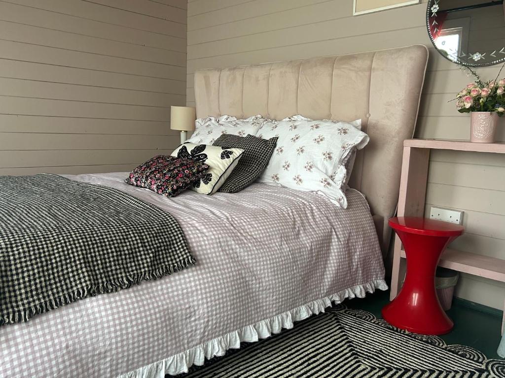 a bedroom with a bed with pillows on it at The Dairy stylish chalet for 2 opp the beach 1 minute walk in Whitstable