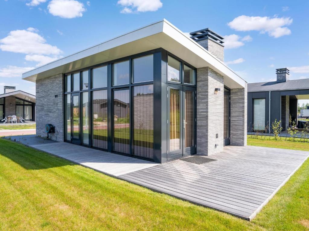 a house with glass doors on a lawn at Leiden in Oud-Ade
