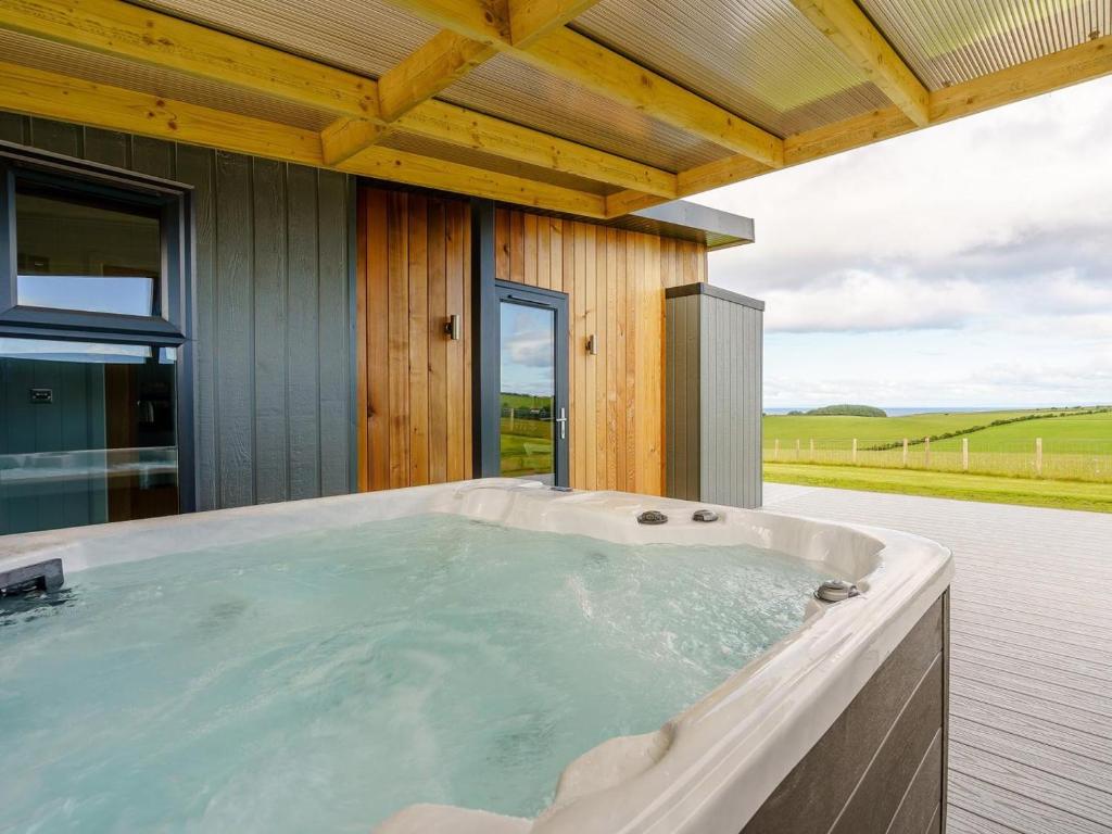a hot tub on the deck of a house at 1 Bed in Girvan oc-78072 in Girvan