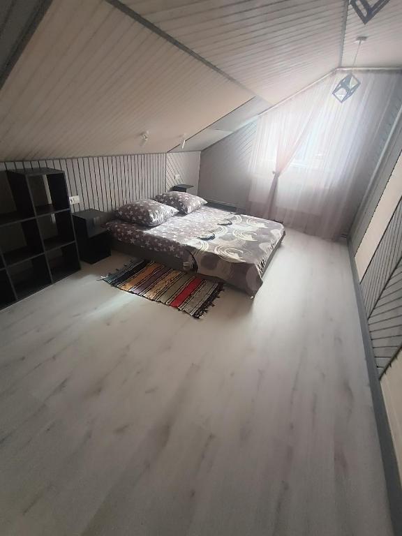 a bed in a small room with a wooden floor at Міні садиба in Lazeshchyna