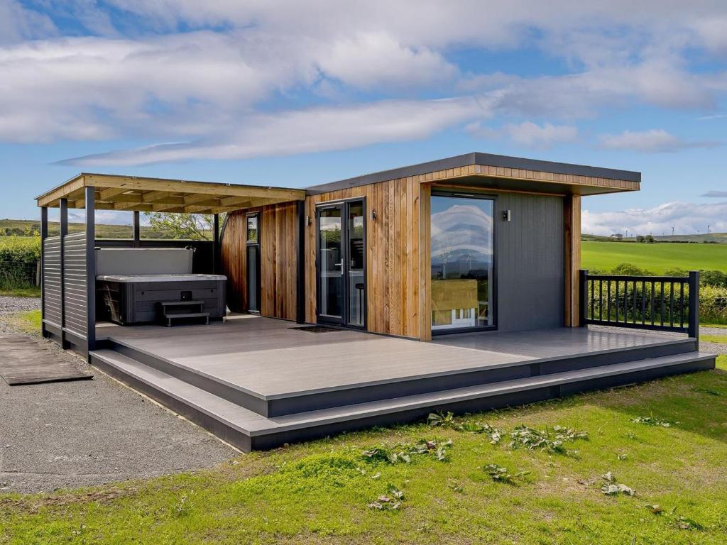a small house with a deck with a grill at 1 Bed in Girvan oc-78073 in Girvan