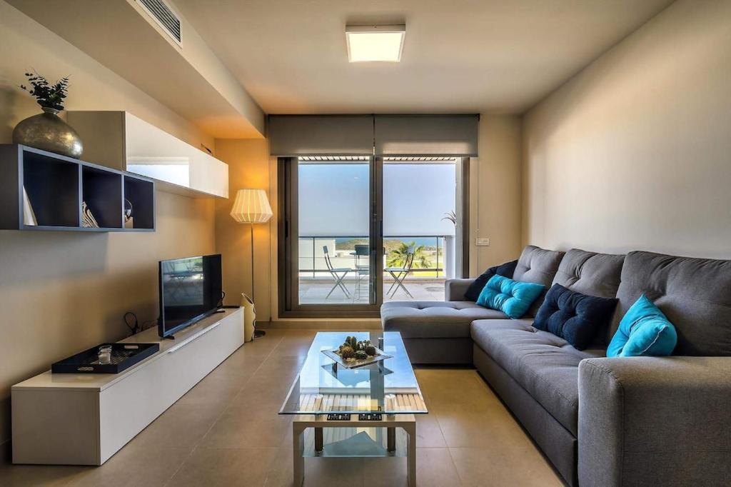 a living room with a couch and a tv at Casa Paulo - Aguilón Golf in San Juan de los Terreros