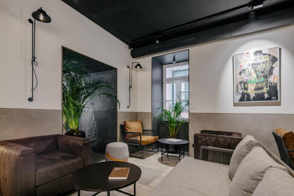 A relaxed lounge with sofas, armchairs, round tables and indoor plants.