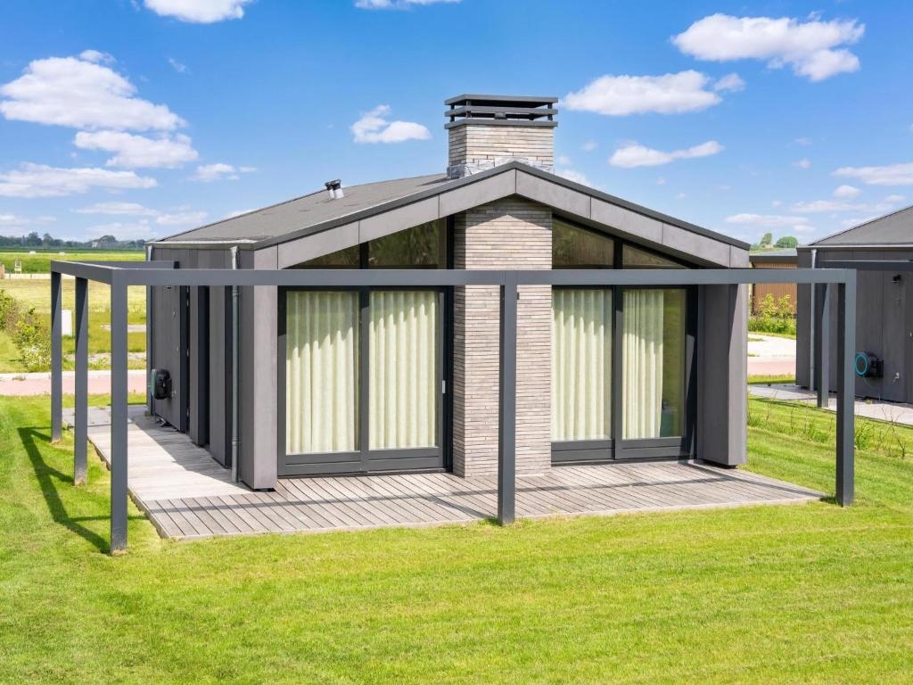 a house with a deck in the grass at Strand in Oud-Ade