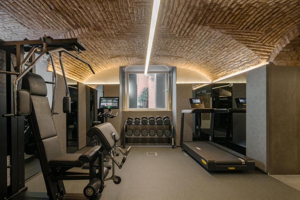 A compact fitness room in a vaulted brick-lined space.