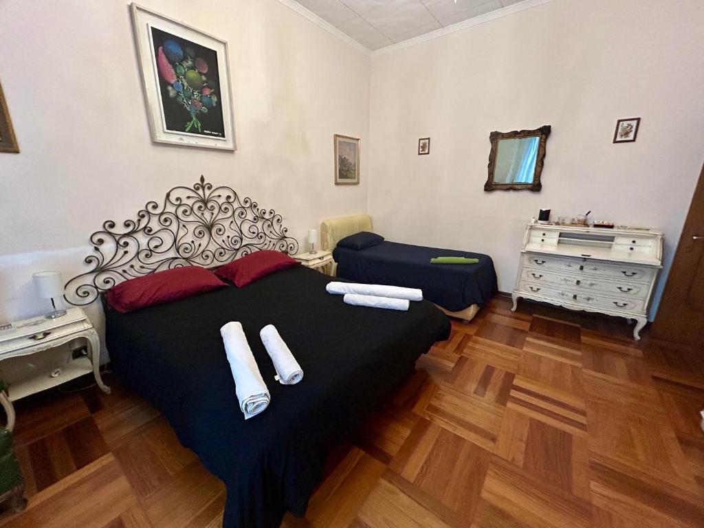 a bedroom with a large black bed with towels on it at Suite in Private Villa in Milan