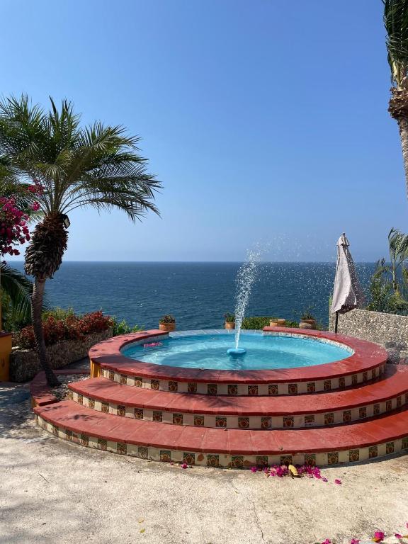 a fountain on steps with the ocean in the background at Habitacion Mar in Puerto Escondido