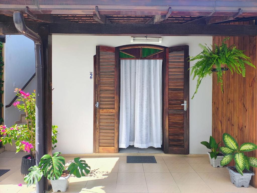 a room with a door with a curtain and plants at Apartamento Canasvieiras in Florianópolis