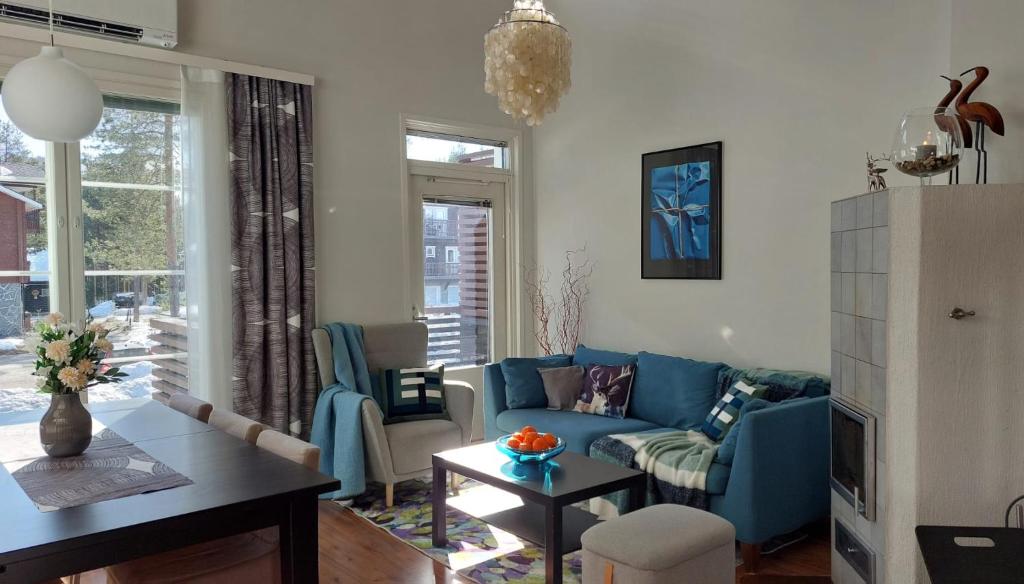 a living room with a blue couch and a table at Levin Lumienkeli A6 in Levi