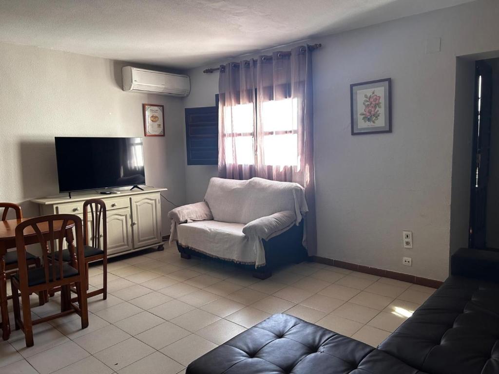 a living room with a chair and a television at cerronegro con terraza in Capileira