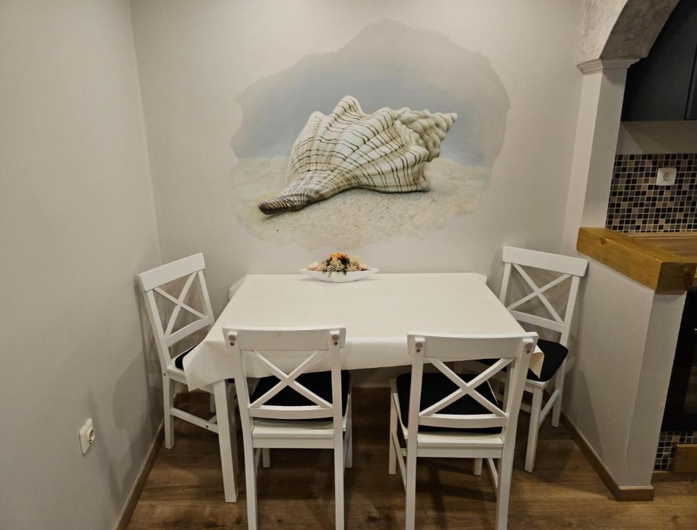 a dining room with a white table and chairs at Sea Paradise Piran in Piran