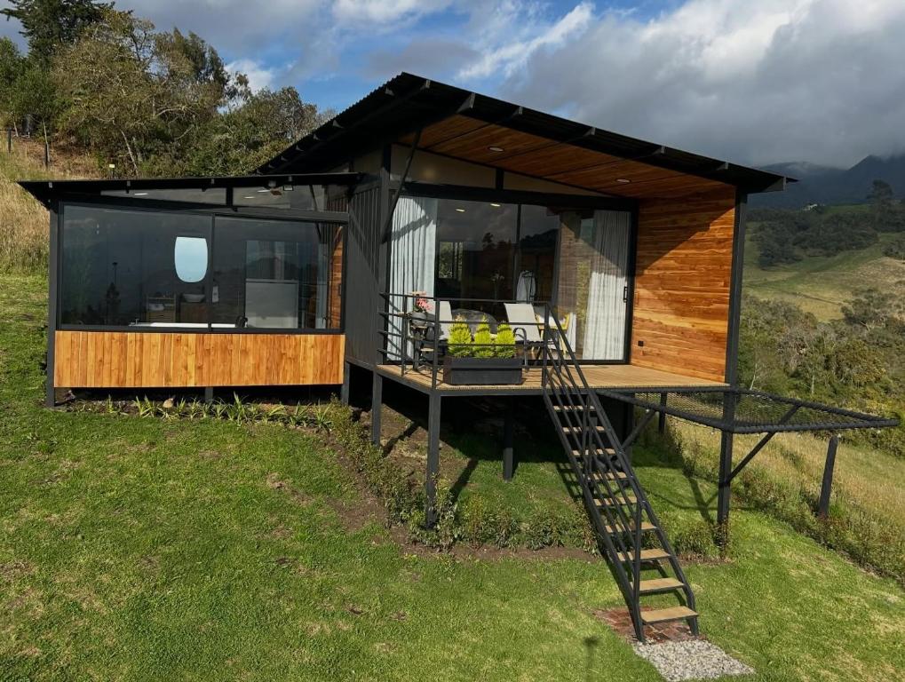 a house on a hill with a staircase at Cabañas El Abuelo in La Calera