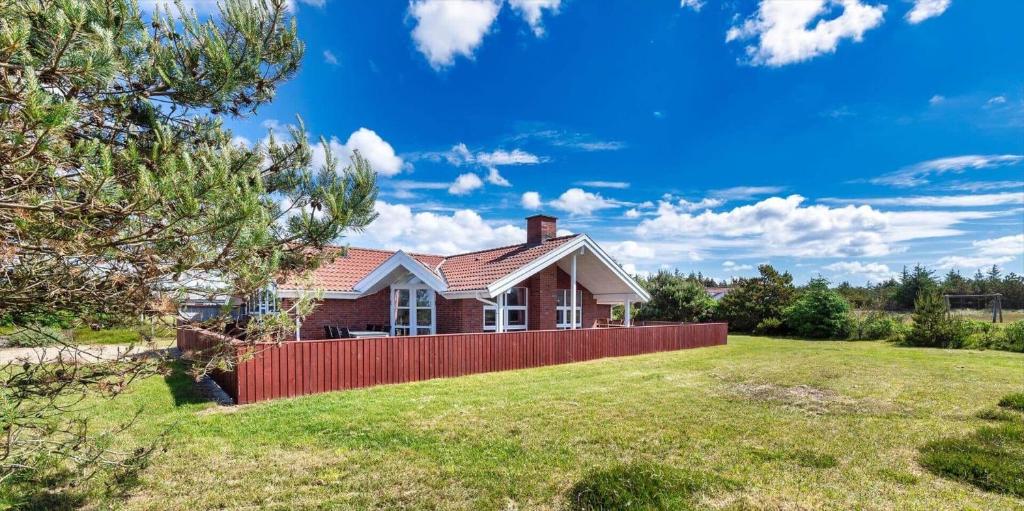 a house with a red fence in a yard at VE047-Vejers-Strand-Jafdalvej-91 in Vejers Strand