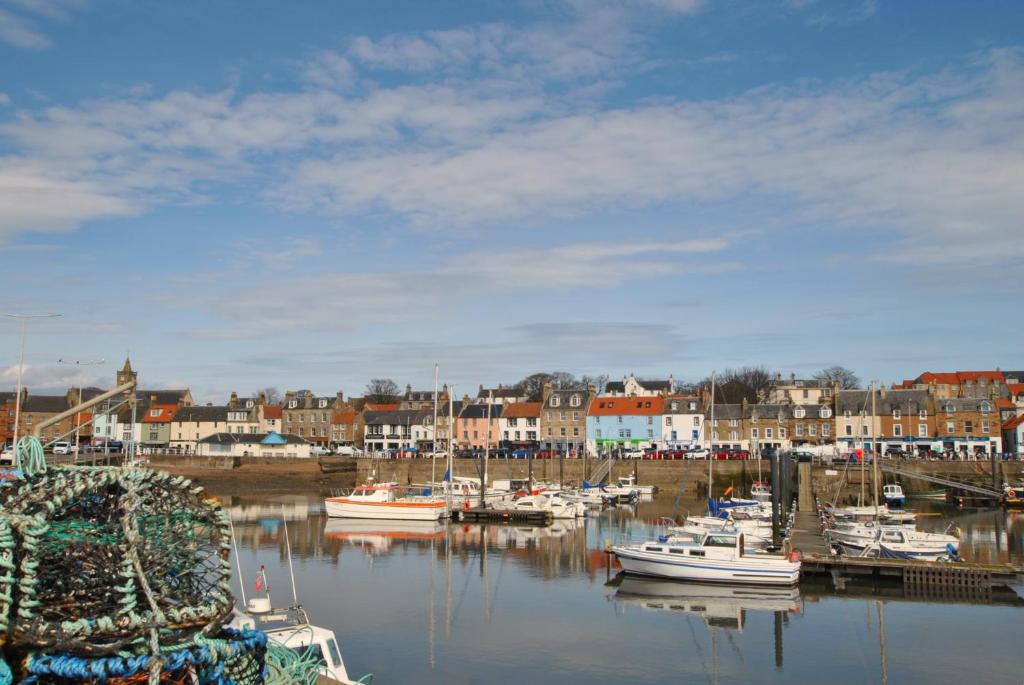 a group of boats are docked in a harbor at Harbourside Apartment in Anstruther